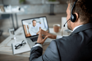 side perspective businessman wearing suite on video call on a laptop with it consultant
