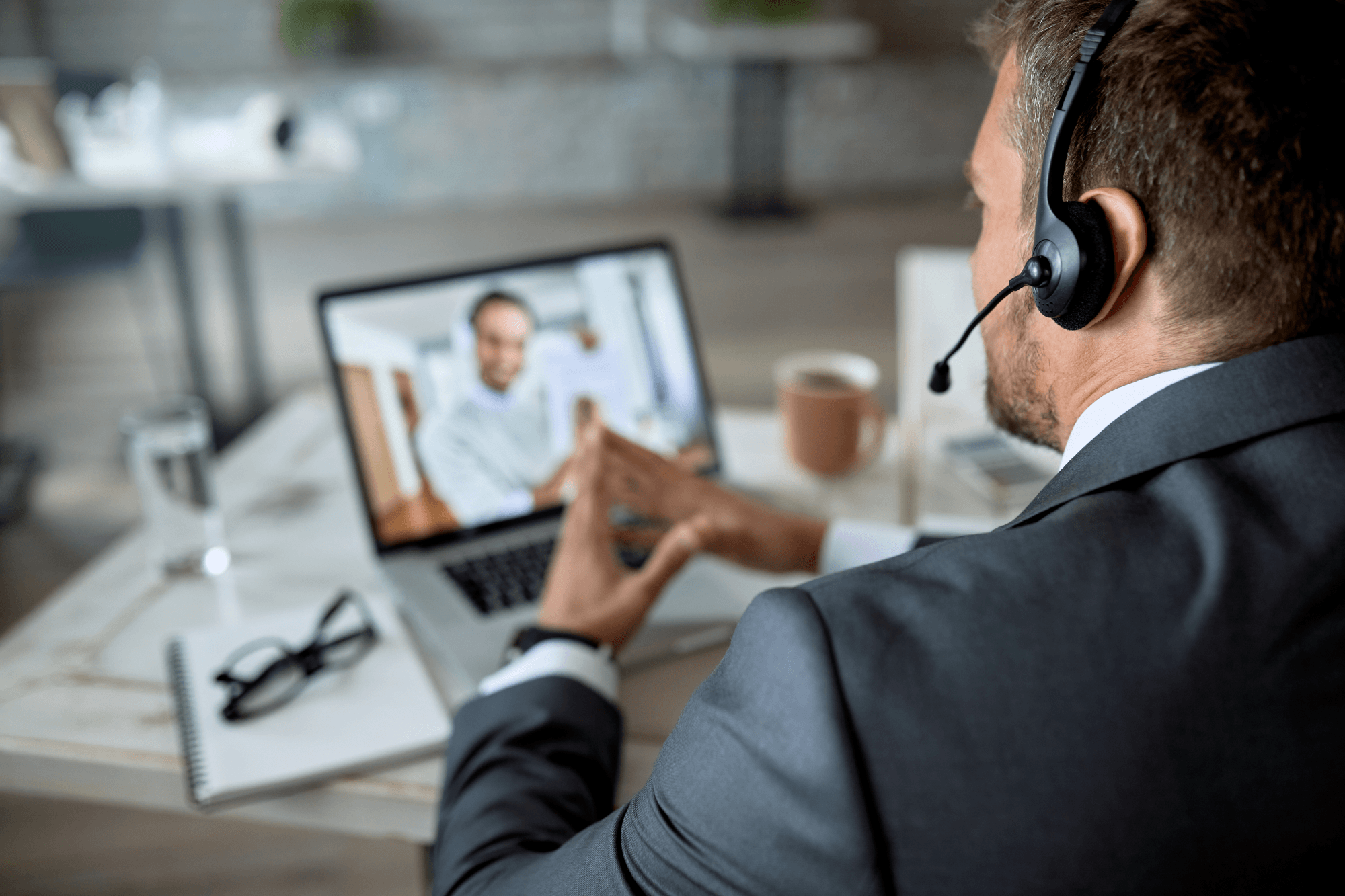 side perspective businessman wearing suite on video call on a laptop with it consultant